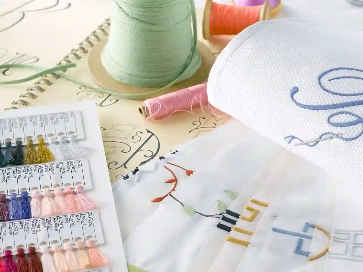 Custom embroidery textile design samples with thread color swatches for premium linen and bedding