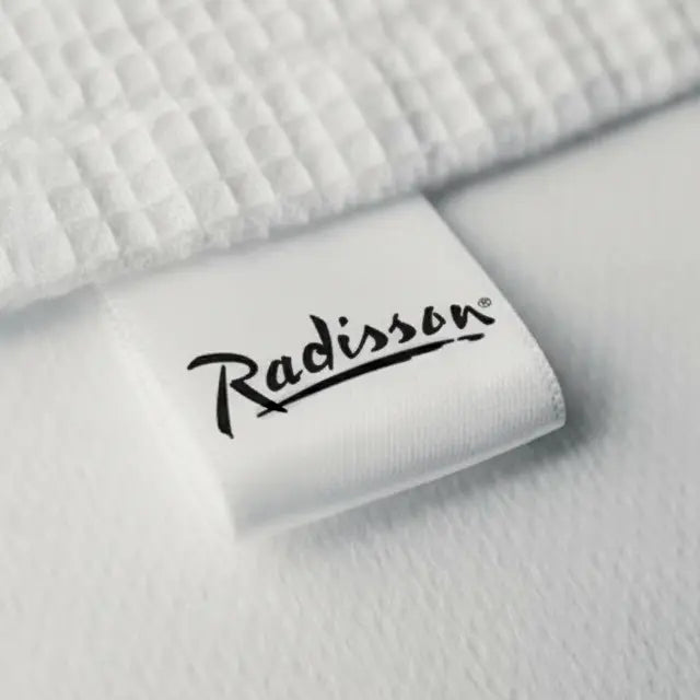Woven brand label attached to premium hotel linen fabric