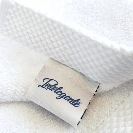 Woven fabric label attached to premium hotel towel linen for textile branding