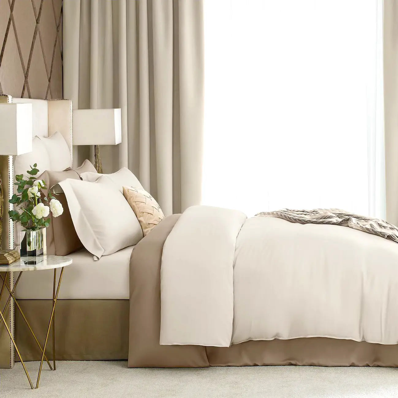 Luxury neutral bed sheet set styled in modern bedroom with layered pillows
