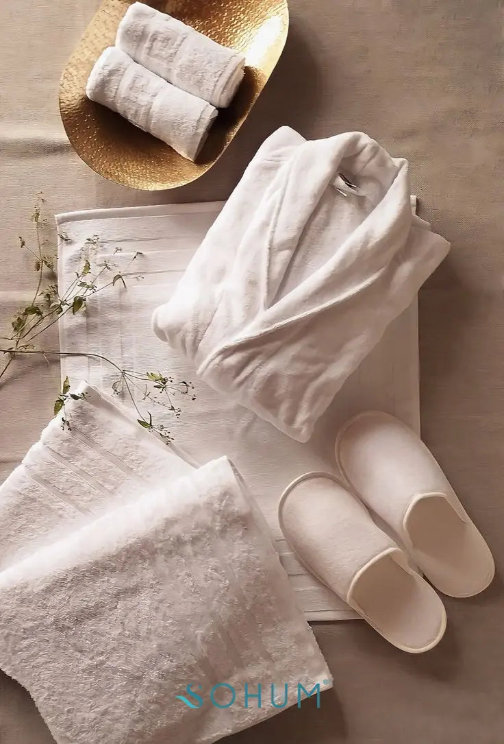 Luxury white bathrobe with towels and slippers in spa setting