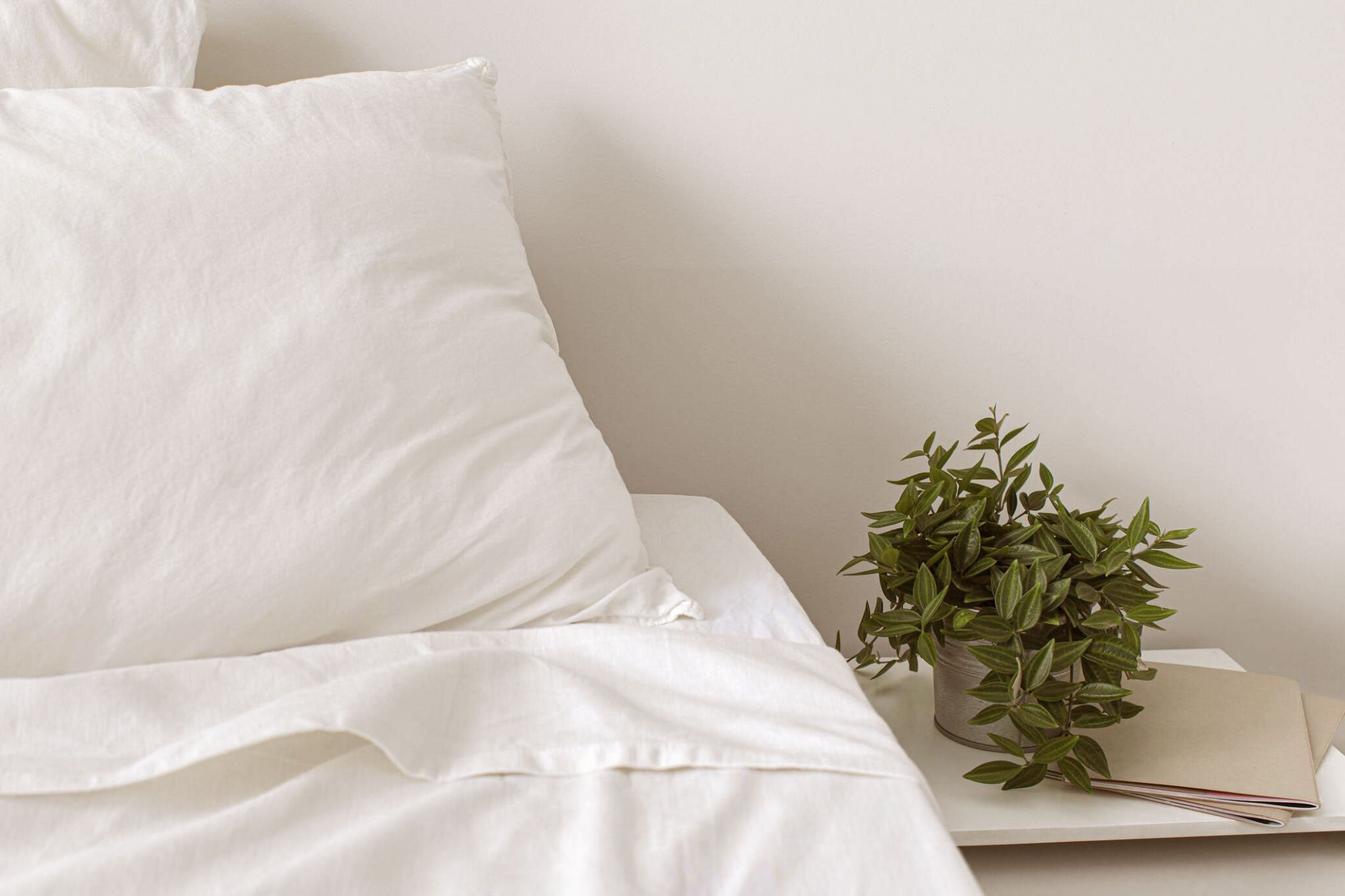 Luxury white pillow and hotel-style bed linen in a minimalist bedroom setting