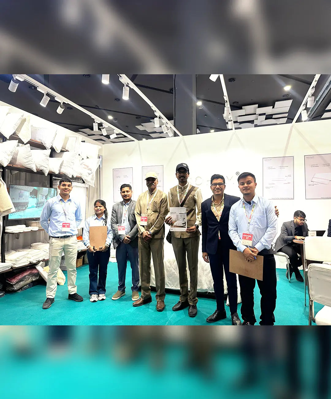 SOHUM bedding and mattress team with visitors at a home textile trade exhibition booth