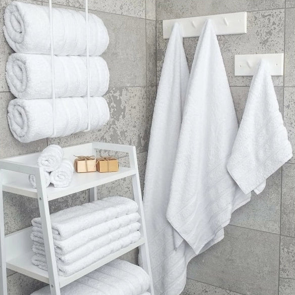 White cotton bath towels neatly arranged in a modern bathroom