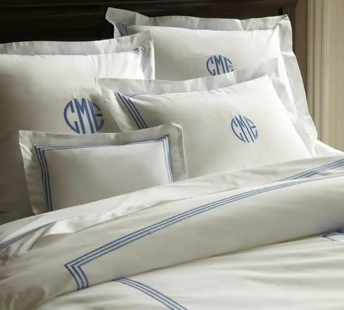 Luxury white bedding set with blue embroidered monogram and border detailing